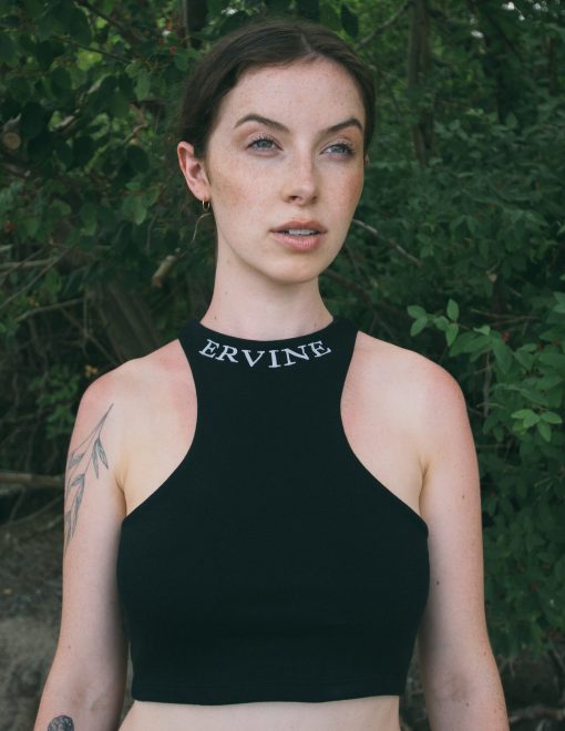model is wearing our reverse racer crop top in the color jet black