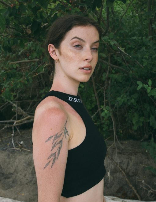 model is wearing our reverse racer crop top in the color jet black